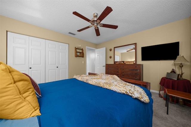 carpeted bedroom featuring baseboards, visible vents, a ceiling fan, a textured ceiling, and a closet