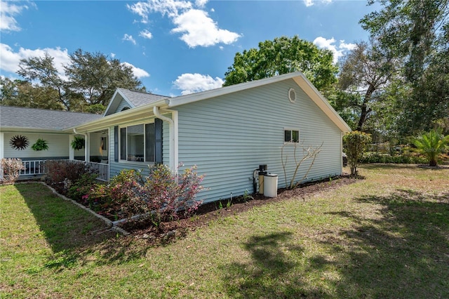 view of home's exterior with a yard and a porch