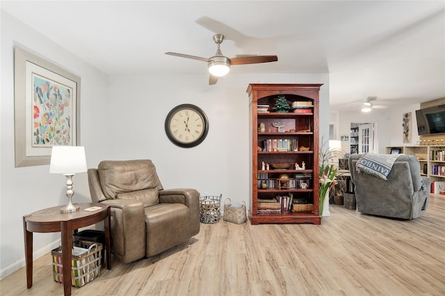 living area with ceiling fan and light hardwood / wood-style flooring