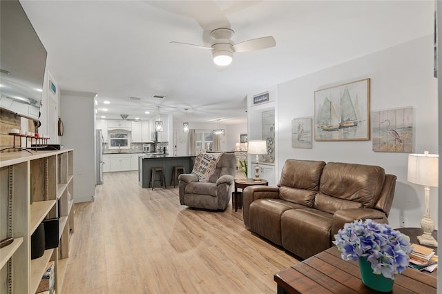 living room featuring ceiling fan and light hardwood / wood-style flooring