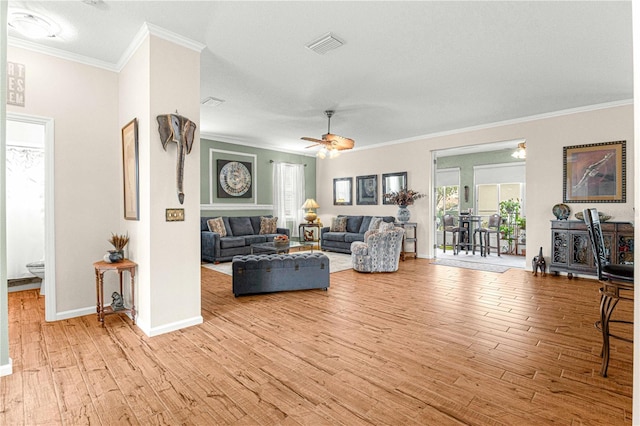 living room with light hardwood / wood-style flooring, ornamental molding, and plenty of natural light