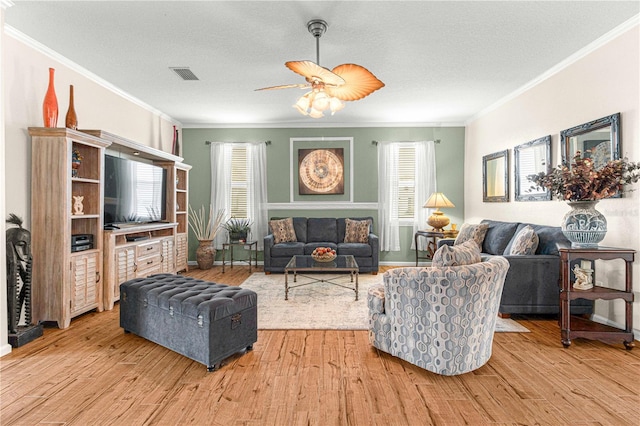 living room with crown molding, a textured ceiling, and light hardwood / wood-style floors