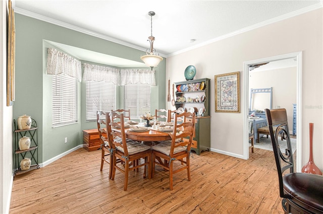 dining room featuring crown molding and light hardwood / wood-style flooring