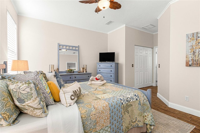 bedroom featuring ornamental molding, hardwood / wood-style floors, ceiling fan, and a closet