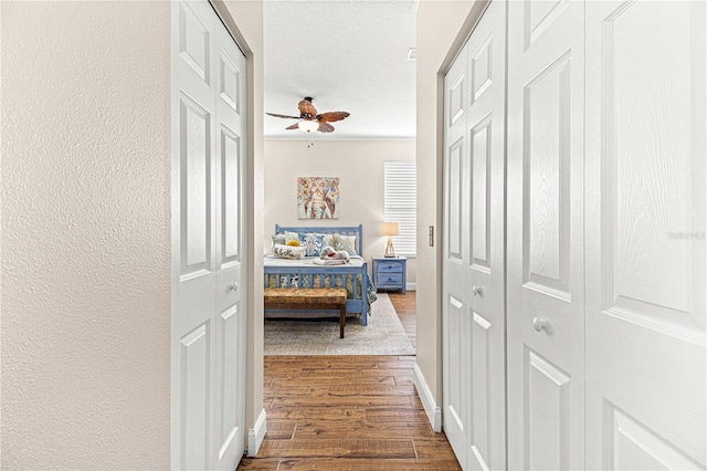 corridor with hardwood / wood-style floors and ornamental molding