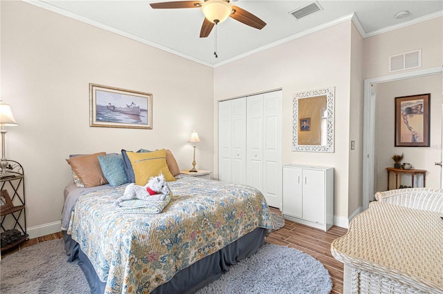 bedroom featuring crown molding, light hardwood / wood-style flooring, a closet, and ceiling fan