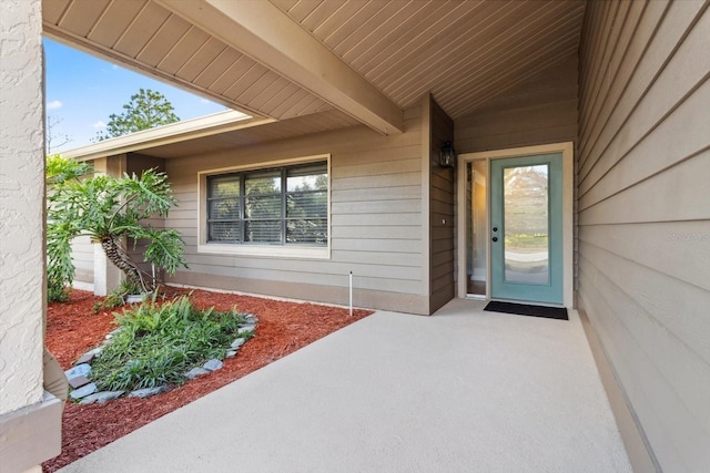 view of exterior entry with a patio