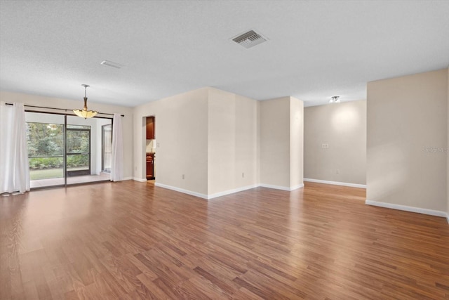 spare room with hardwood / wood-style flooring and a textured ceiling