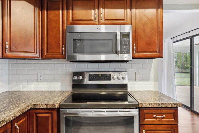 kitchen featuring decorative backsplash, light stone countertops, and stainless steel appliances