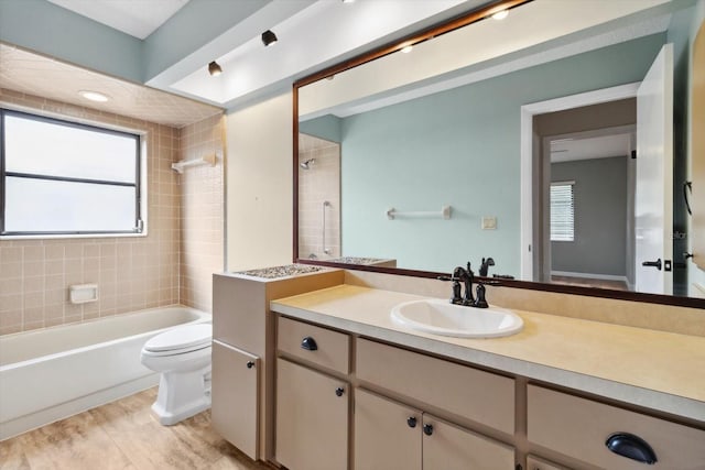 full bathroom with toilet, vanity, and tiled shower / bath combo