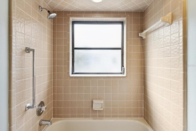 bathroom with a healthy amount of sunlight and tiled shower / bath