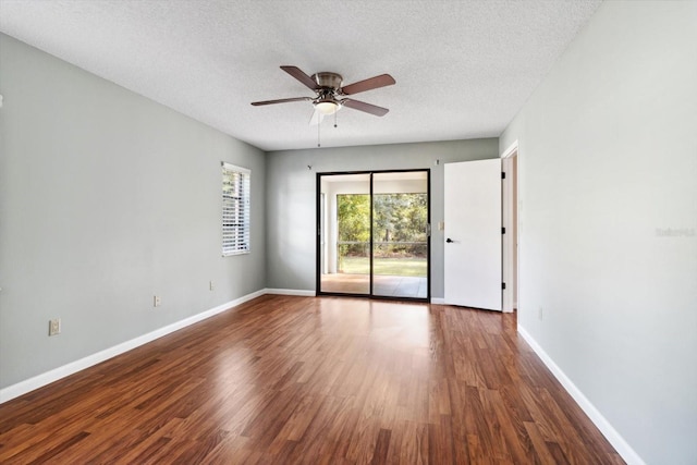 spare room with a textured ceiling, dark hardwood / wood-style floors, and ceiling fan