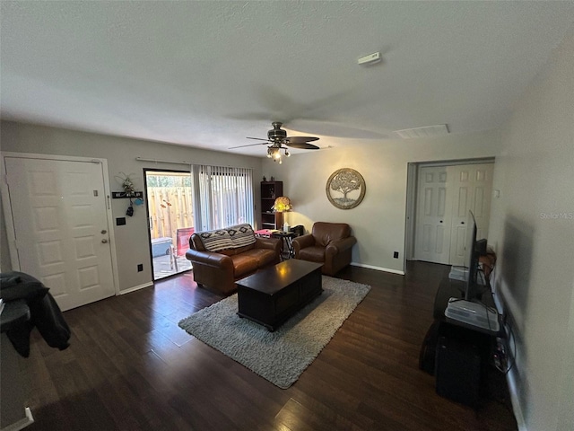 living room featuring dark hardwood / wood-style floors, a textured ceiling, and ceiling fan