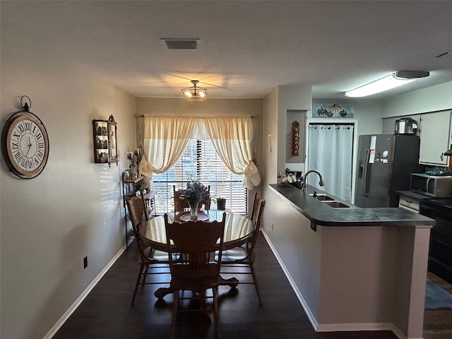 dining space with dark wood-type flooring and sink