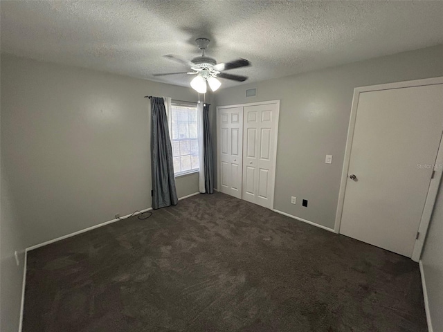 unfurnished bedroom with ceiling fan, a textured ceiling, and dark colored carpet