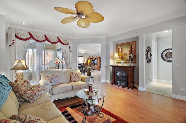 living room with hardwood / wood-style floors, ornamental molding, and ceiling fan