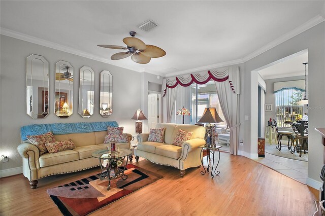 living room featuring crown molding, ceiling fan, and wood-type flooring