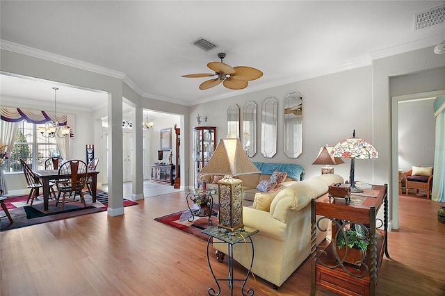 living room with ornamental molding, ceiling fan with notable chandelier, and hardwood / wood-style floors