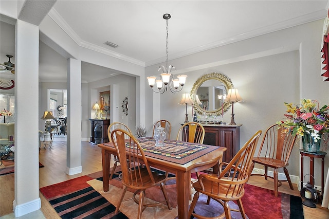 dining room featuring ceiling fan with notable chandelier, ornamental molding, and light hardwood / wood-style floors