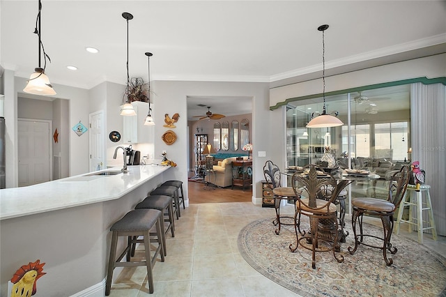 kitchen featuring pendant lighting, sink, and crown molding