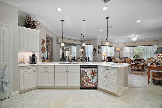 kitchen with sink, dishwasher, ornamental molding, white cabinets, and decorative light fixtures