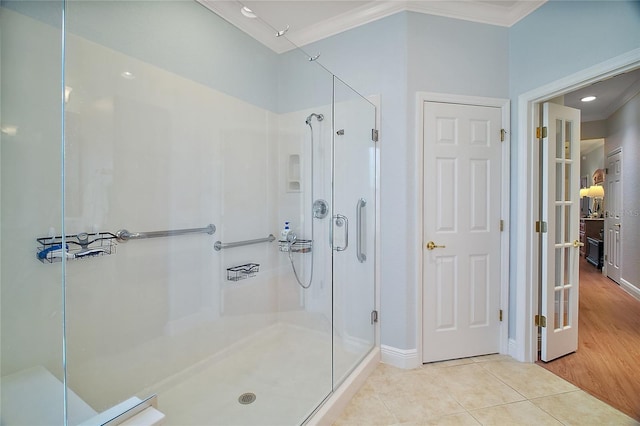 bathroom with an enclosed shower, ornamental molding, and tile patterned floors