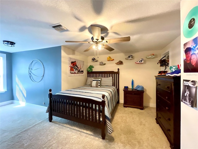 carpeted bedroom featuring a textured ceiling and ceiling fan