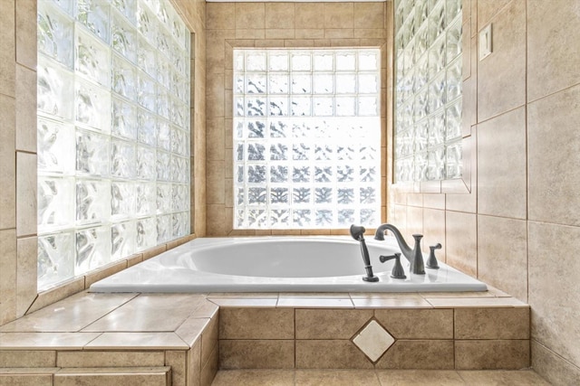 bathroom featuring tiled tub and tile walls