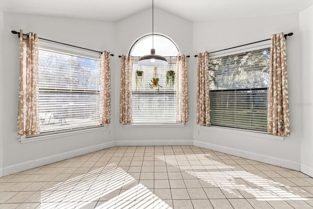 unfurnished dining area with lofted ceiling and light tile patterned floors