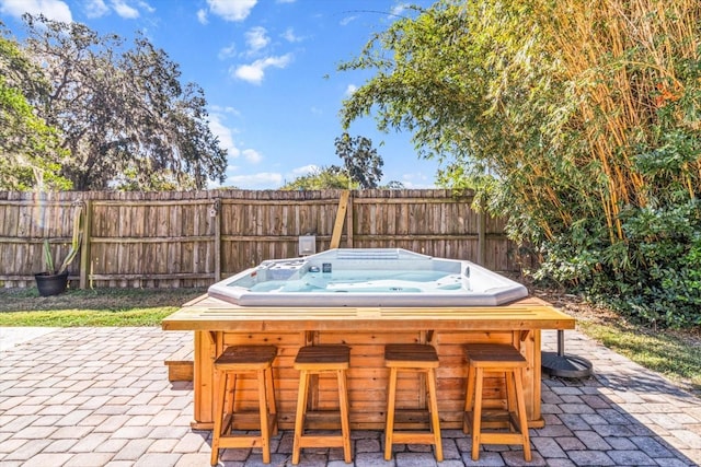 view of patio featuring a hot tub and exterior bar