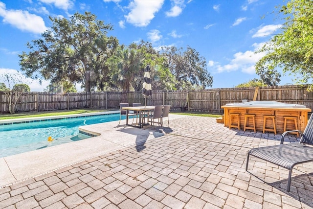 view of swimming pool with a patio area and a hot tub