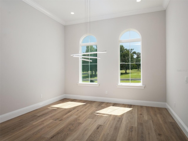 unfurnished room with crown molding, wood-type flooring, and a healthy amount of sunlight