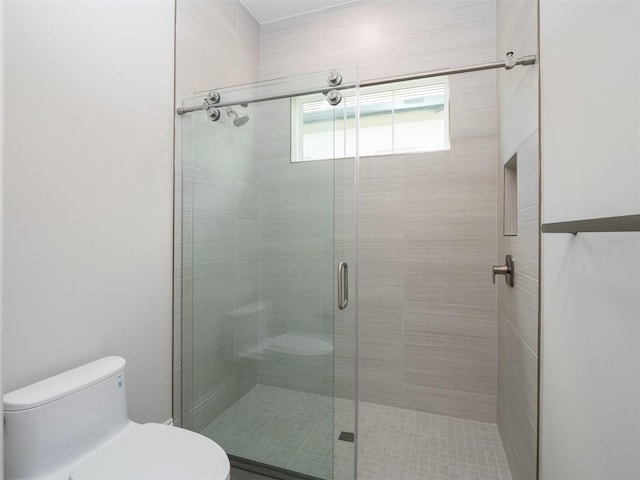 bathroom with toilet and an enclosed shower