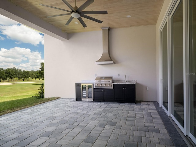 view of patio with area for grilling, sink, wine cooler, and ceiling fan