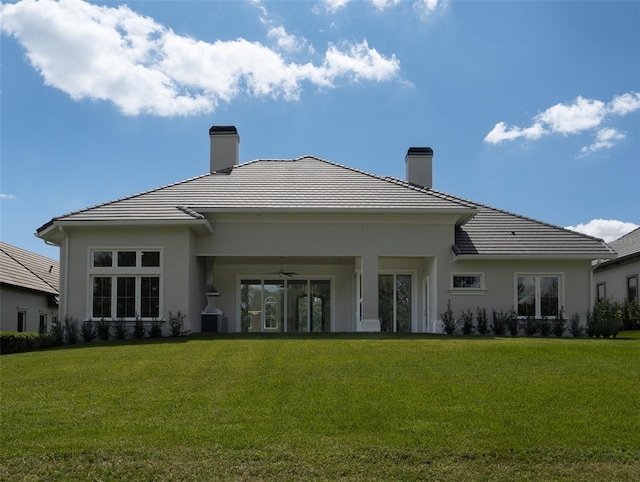 back of property with ceiling fan and a lawn