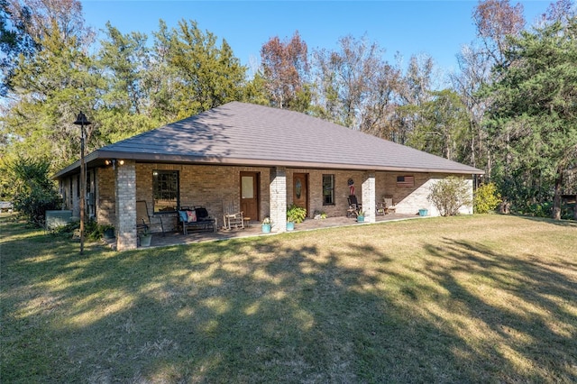 back of property with a yard and a patio