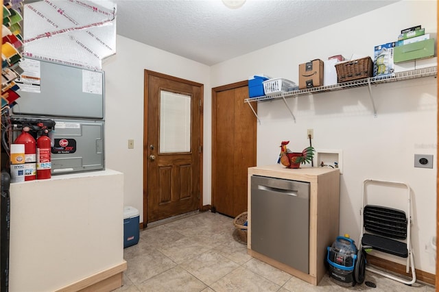 laundry room with washer hookup, hookup for an electric dryer, a textured ceiling, and light tile patterned floors