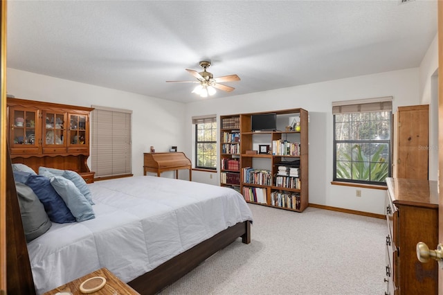 bedroom with multiple windows, ceiling fan, and carpet flooring