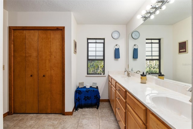 bathroom featuring vanity, tile patterned floors, and a textured ceiling