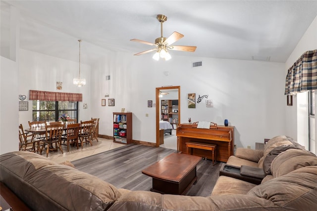 living room with lofted ceiling, hardwood / wood-style floors, and ceiling fan with notable chandelier