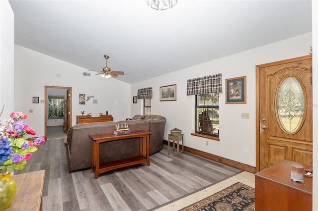 living room featuring vaulted ceiling, ceiling fan, and light hardwood / wood-style flooring