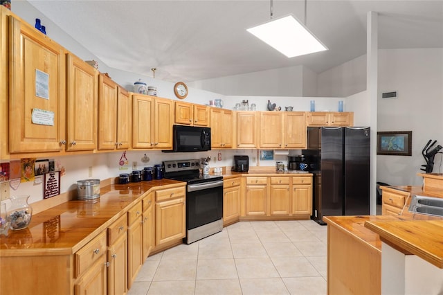 kitchen with light brown cabinetry, butcher block countertops, vaulted ceiling, light tile patterned floors, and stainless steel appliances