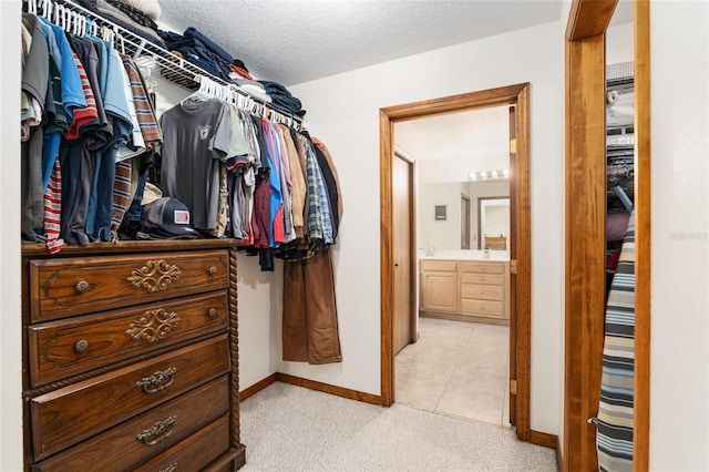 walk in closet featuring light carpet