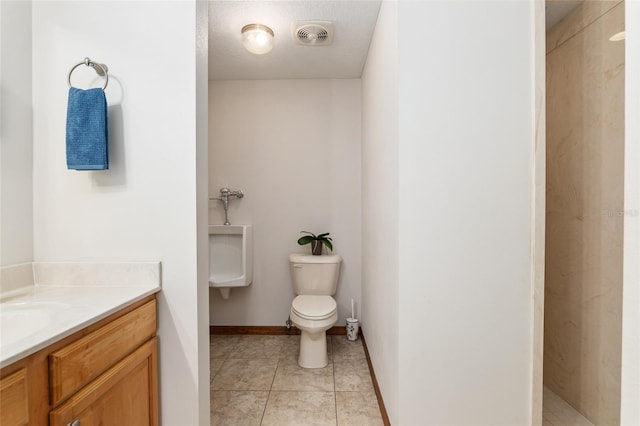 bathroom with vanity, tile patterned flooring, a textured ceiling, and toilet