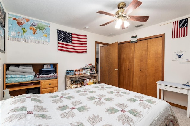 carpeted bedroom featuring a textured ceiling, a closet, and ceiling fan