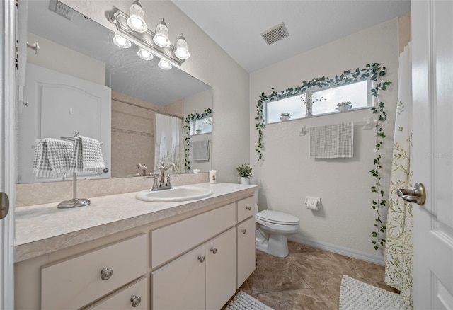 bathroom with vanity, toilet, and tile patterned flooring