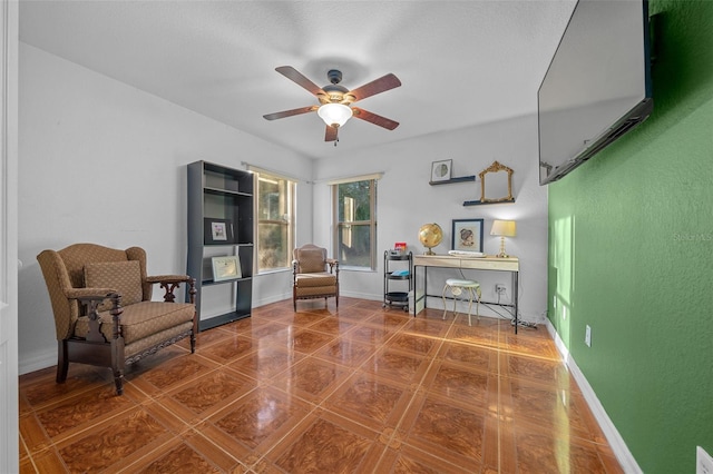 living area featuring tile patterned floors and ceiling fan