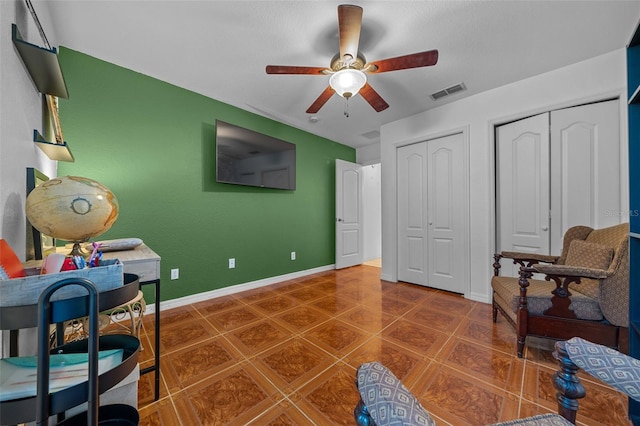 interior space featuring ceiling fan and dark tile patterned flooring