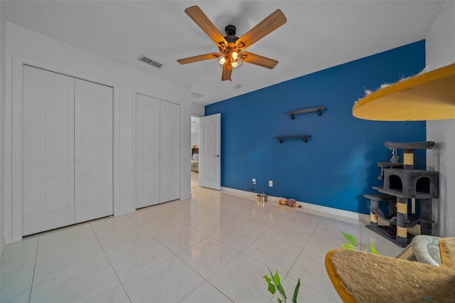 tiled bedroom featuring ceiling fan