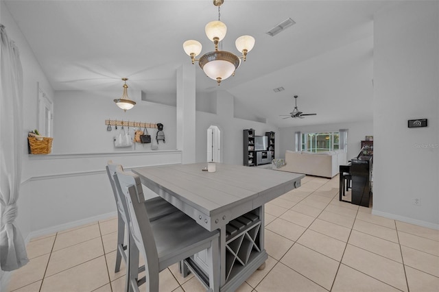 tiled dining space with ceiling fan and vaulted ceiling